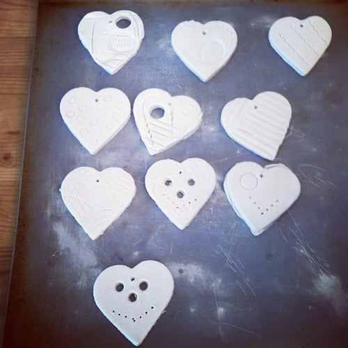 White heart-shaped ceramic ornaments with various embossed patterns and small holes for hanging.