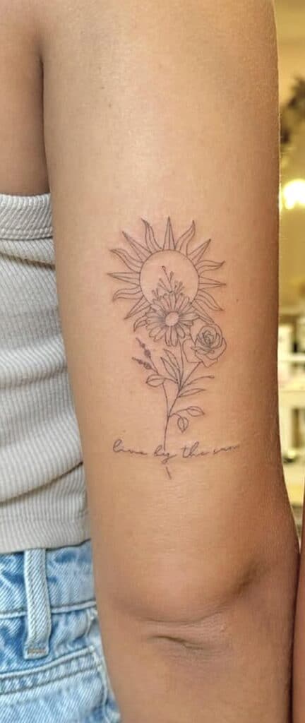 Delicate sunflower and rose floral tattoo with handwritten quote.
