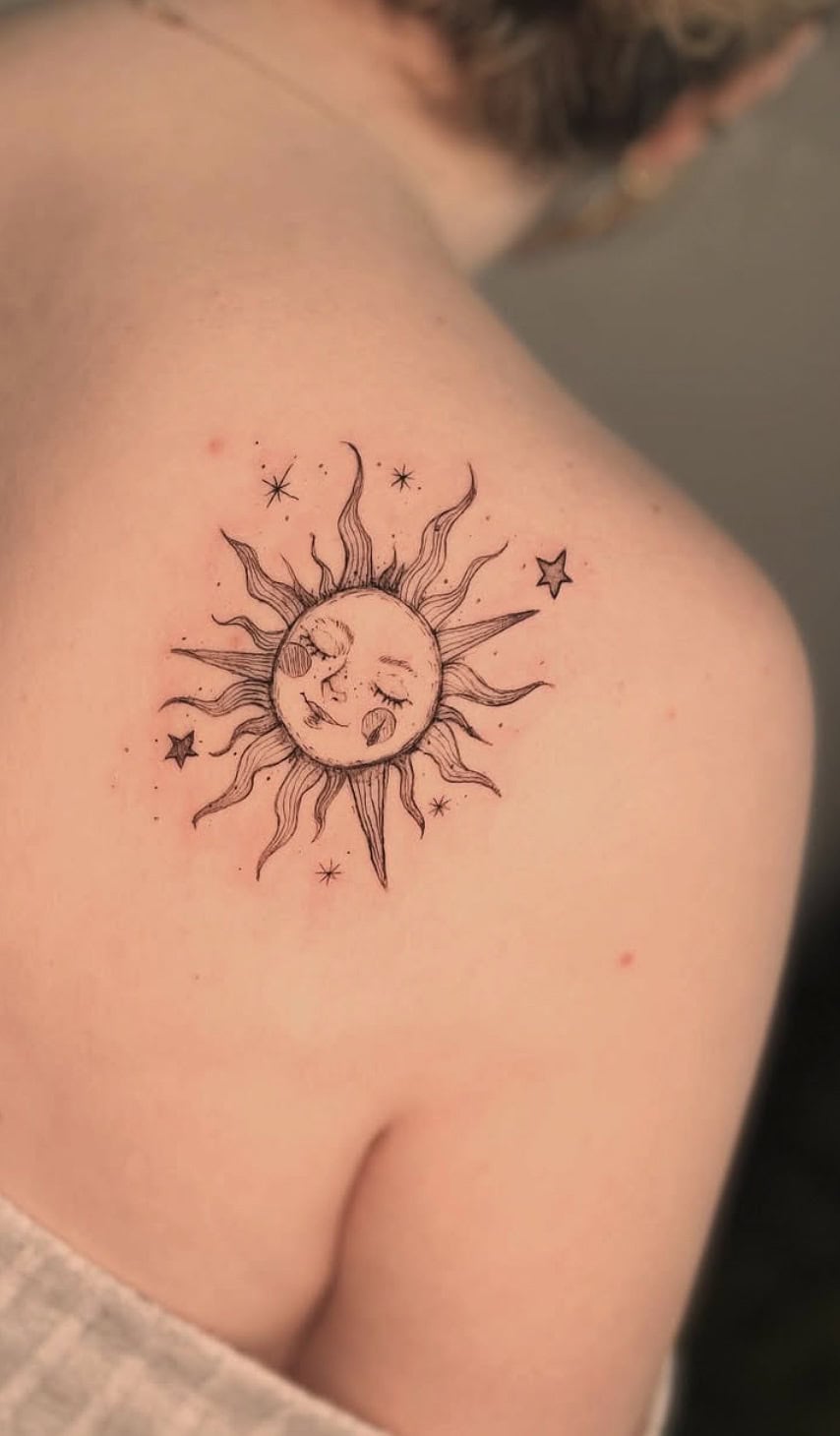 A detailed black ink sun and moon tattoo with stars, on shoulder, celestial tattoo art style.