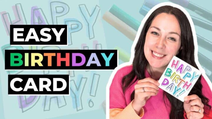 Woman holding colorful handmade birthday card with 'Happy Birthday' message.