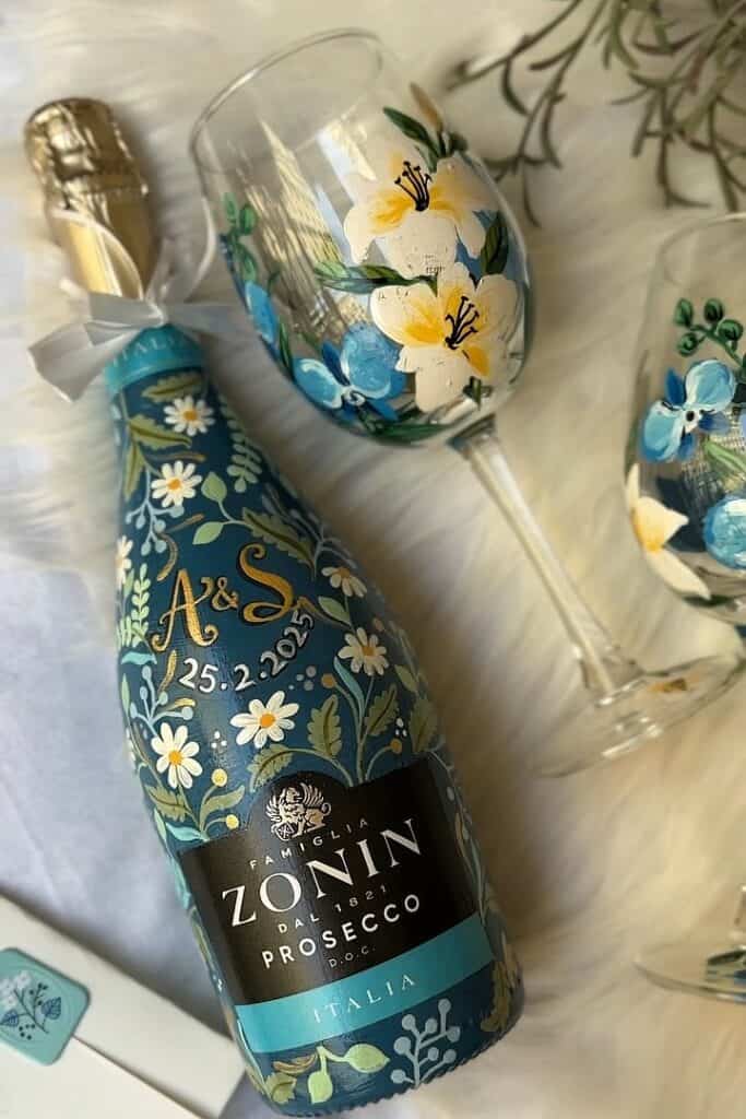 Decorative floral painted wine bottle and glasses for special occasions.