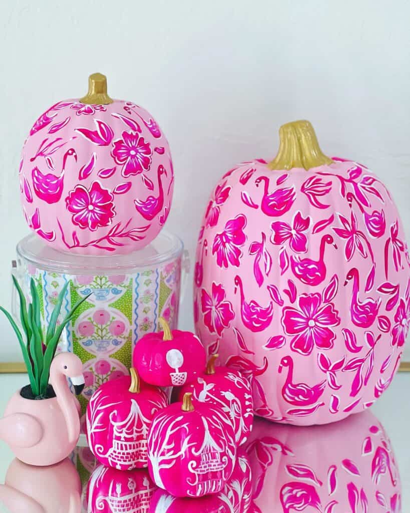 Decorative pink pumpkins with floral and bird patterns for fall season.